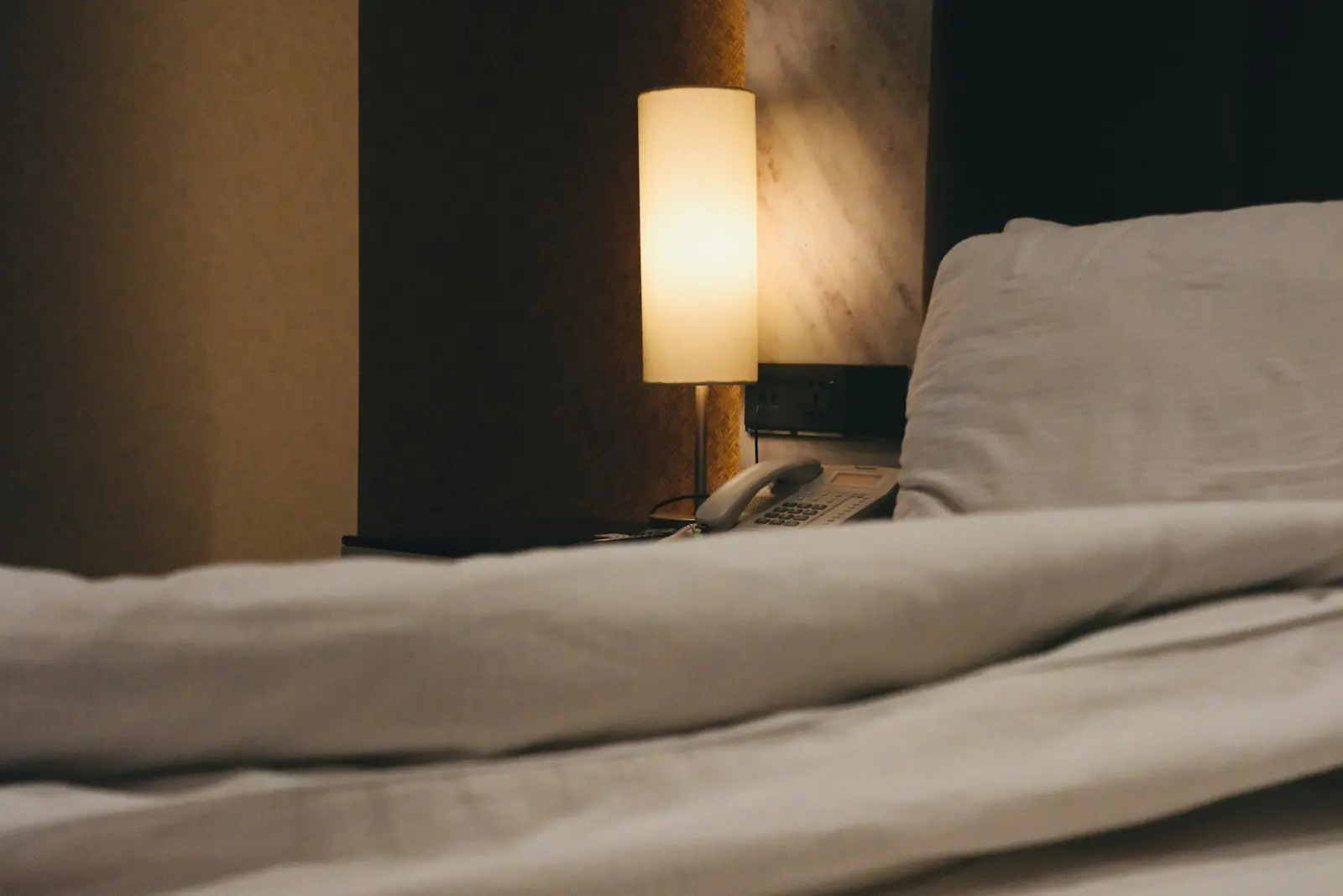 A bed with a lamp on beside it
