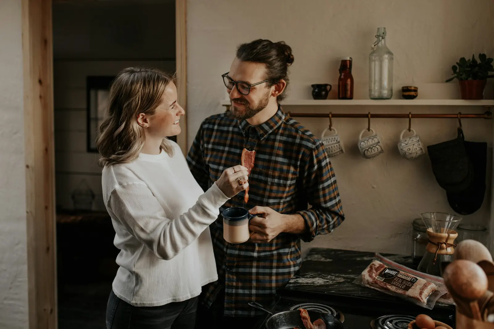 A couple with mugs in the kitchen in the morning