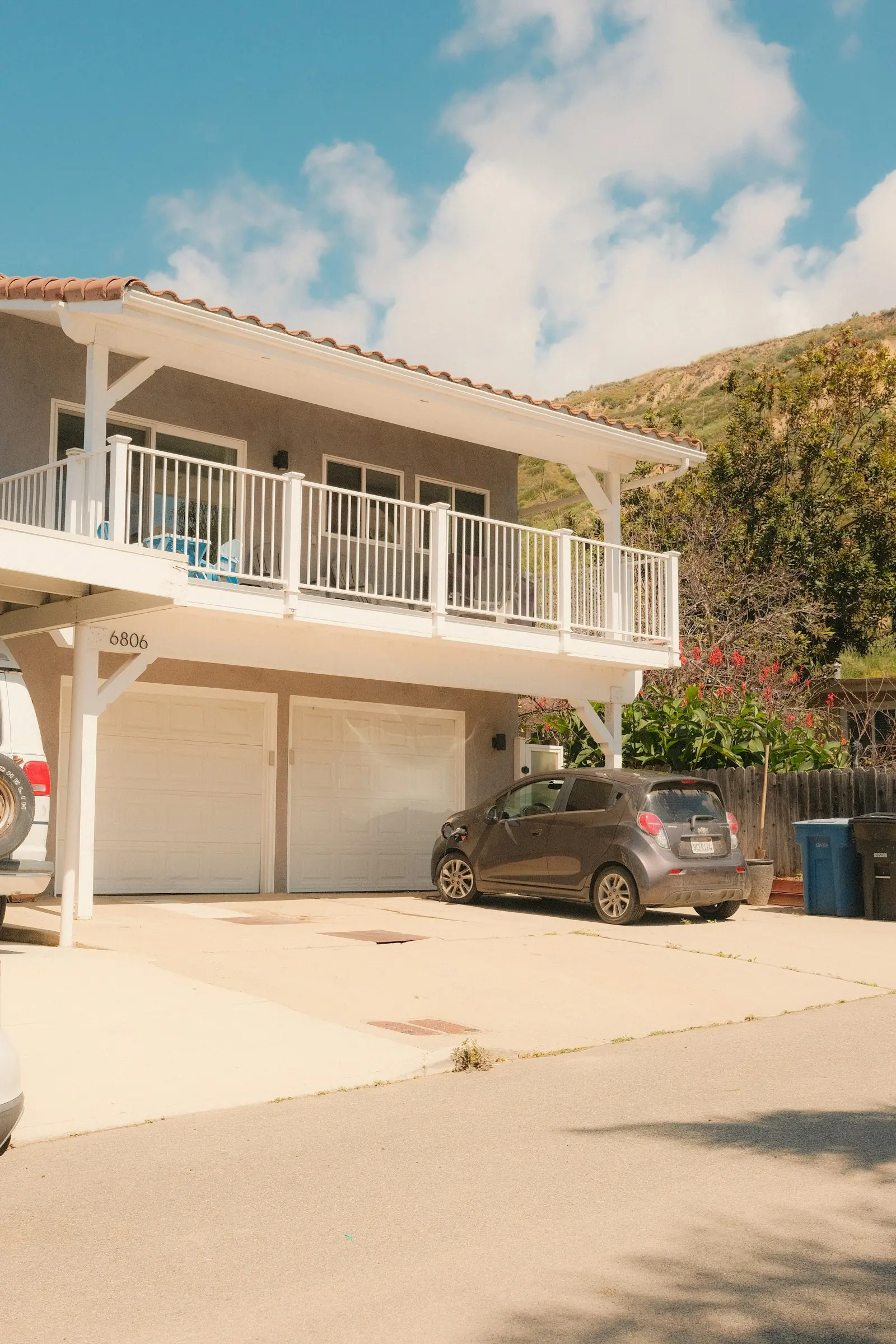 A house with a two-car garage and a car on the drive on a sunny day